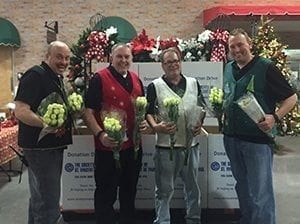 Arizona Flower Market gave a dozen wrapped white roses from a fair trade farm in Africa to toy and food donors. From left: Brent Denham, Bill Denham, Rob Miller and Brad Denham.