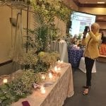 Cyleste Mackey taking a photo of event flowers with her cell phone