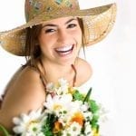 smiling women with a sun hat and a bouquet of flowers