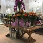 A wood table with orange, purple and green flowers