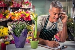 Male florist on the phone taking an critical order