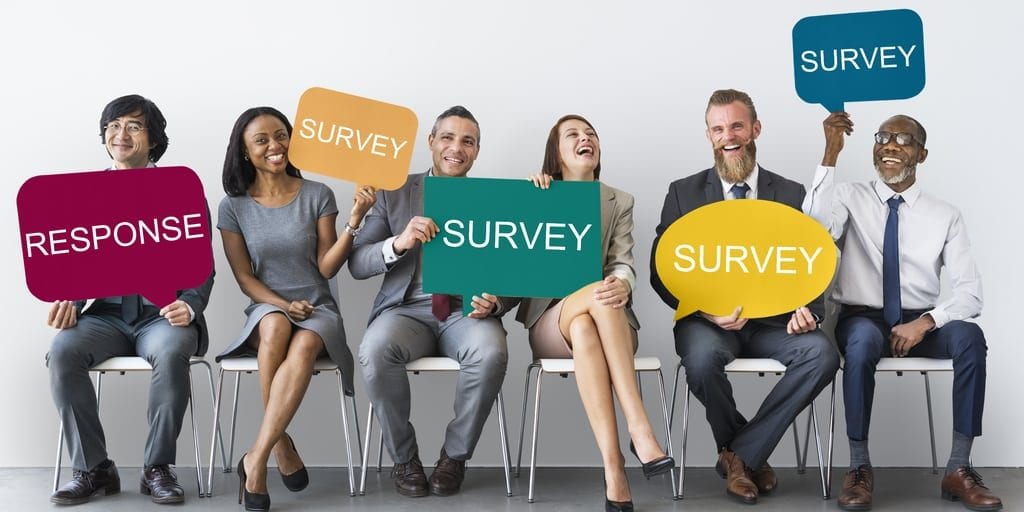 stock image of several people holding signs for a survey