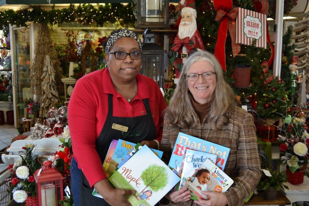 Jill Williams, manager of Royer’s Flowers & Gifts’ Lancaster, Pennsylvania, (left) offers Renee Christiansen, youth services manager of the Library System of Lancaster County, children’s books customers donated during the company’s “Bouquets for Books” program.