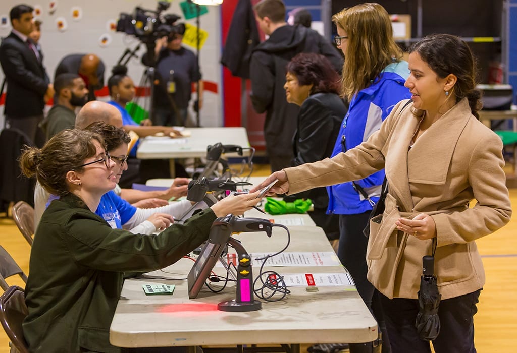 Election officials check voters’ identification during midterm election voting in Arlington, Virginia.