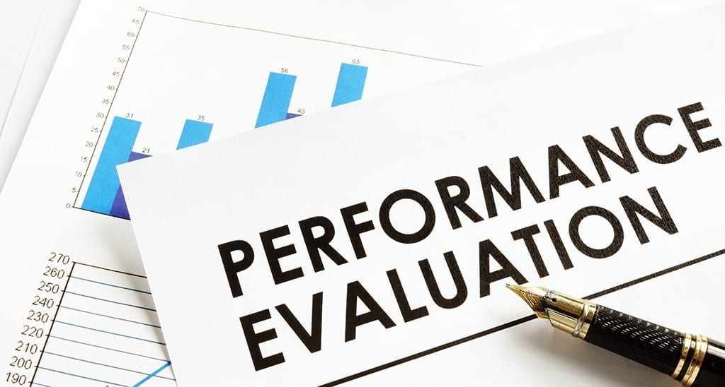 Documents about performance evaluation on a desk.