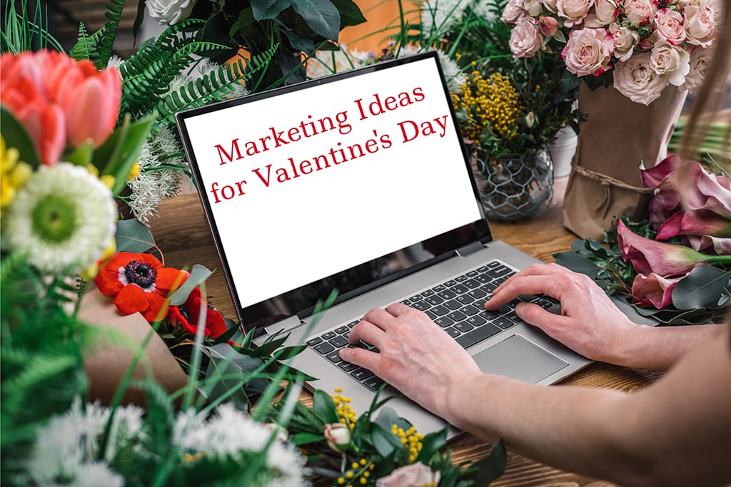 Florist using laptop with blank screen with flowers bouquet