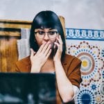 Shocked hipster girl feeling excited of receiving news about upcoming discount during cellphone call with customer service