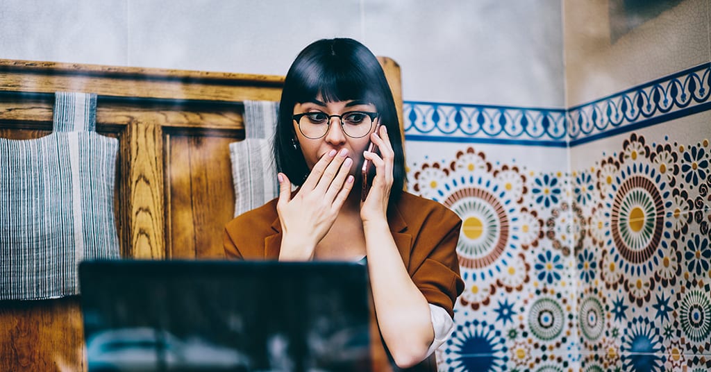 Shocked hipster girl feeling excited of receiving news about upcoming discount during cellphone call with customer service